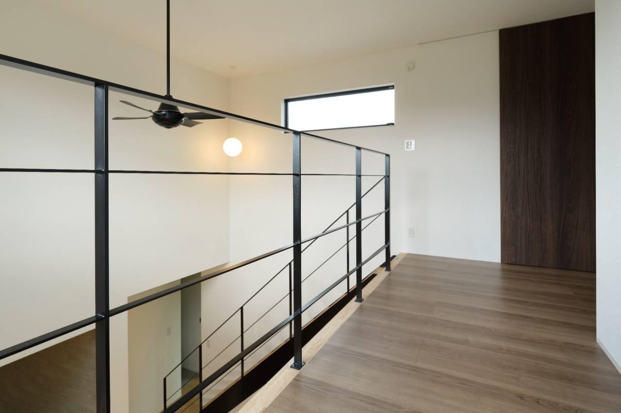 鉄骨階段からつながる2F廊下の手すりが空間のアクセントに