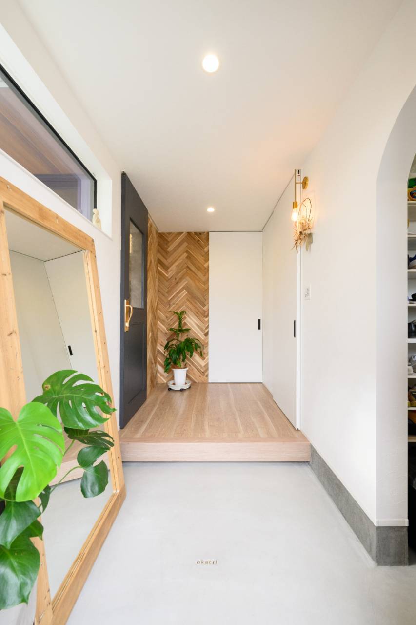 ヘリンボーン貼りの壁が目を引く玄関ホール